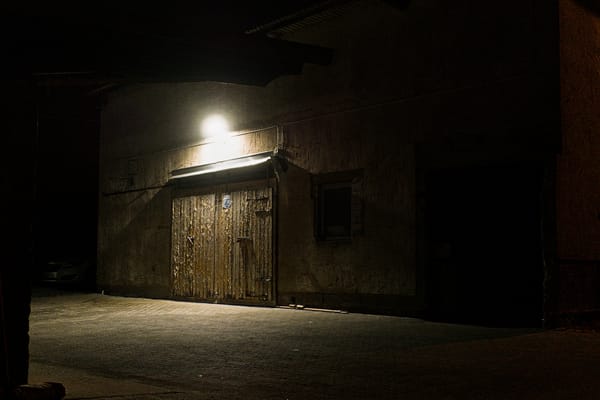 A outbuilding at night, illuminated by a single LED lamp.