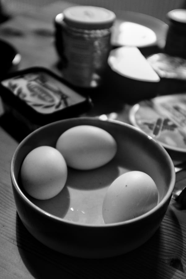 Three duck eggs in a bowl on a breakfast table.